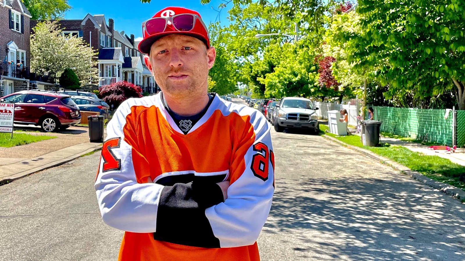 满帆 电影制作 MFA grad 熊猫 Lord in an orange hockey jersey on a residential Philadelphia street.