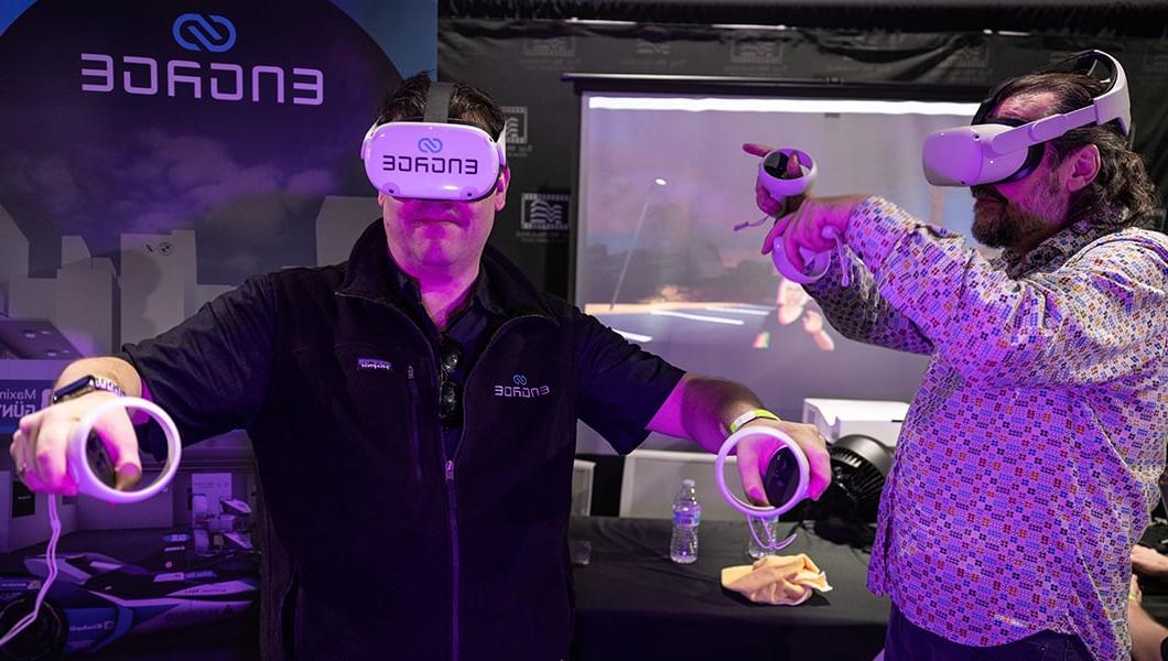 Two men wear virtual reality headsets. 他们都把手臂向上伸展，看起来很开心.